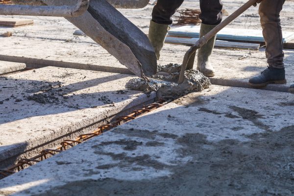 Workers pour the Foundation for the construction of a residential building using mobile concrete mixers
